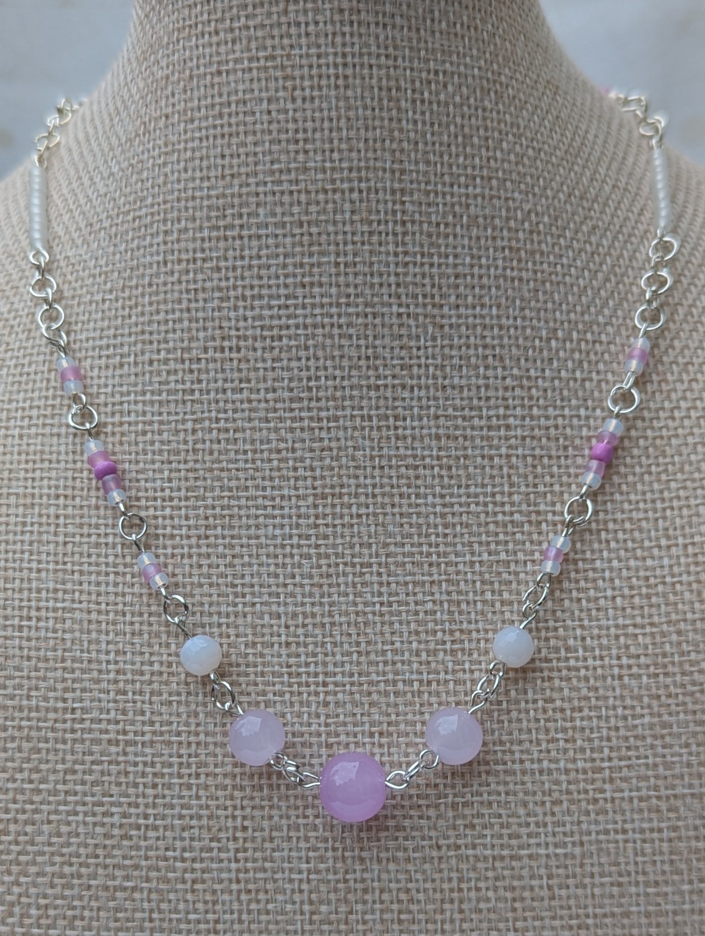 Handmade silver-toned necklace with lavender and pearl-white glass seed beads and five larger lilac stone beads, finished with a silver lobster clasp closure.