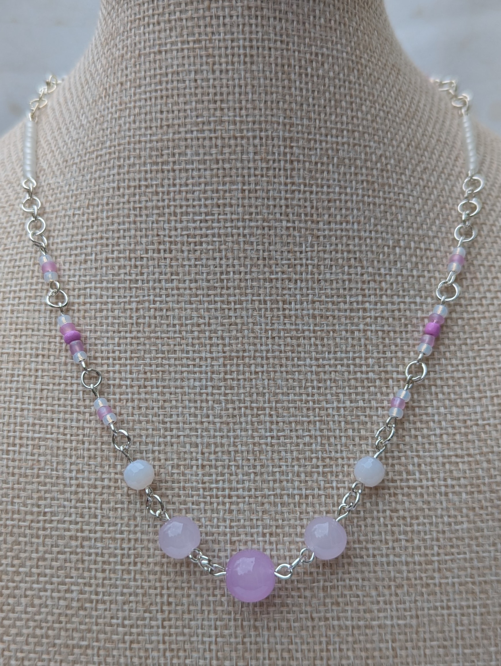 Handmade silver-toned necklace with lavender and pearl-white glass seed beads and five larger lilac stone beads, finished with a silver lobster clasp closure.