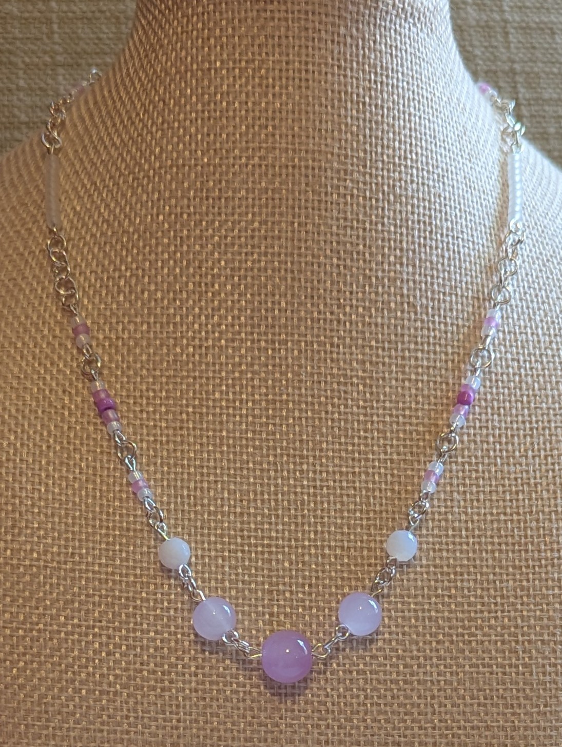 Handmade silver-toned necklace with lavender and pearl-white glass seed beads and five larger lilac stone beads, finished with a silver lobster clasp closure.
