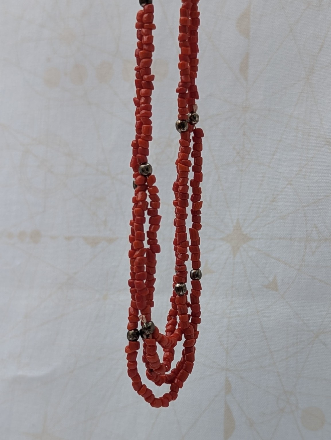 Handmade multi-strand necklace featuring coral red beads on layered thread strands with bronze-colored accent beads and a bronze lobster clasp closure.