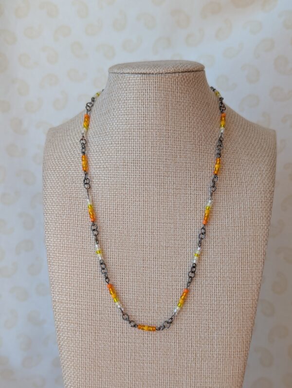 Tungsten-toned chain necklace with gradient orange, yellow, and white glass seed beads and lobster clasp