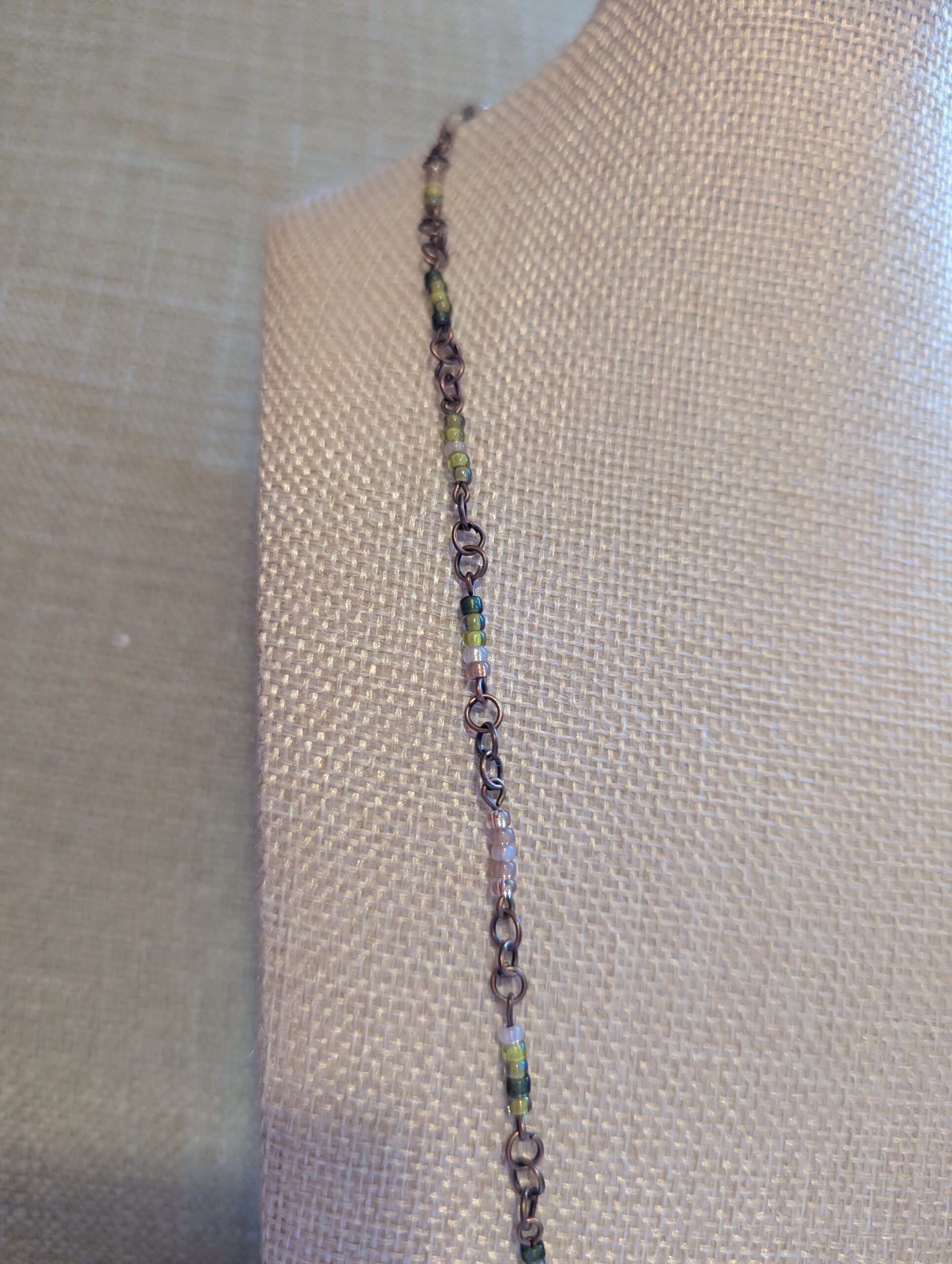 Bronze chain necklace with gradient green glass seed beads in moss, olive, and forest tones with lobster clasp