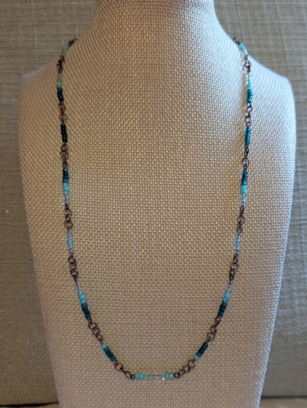 Bronze chain necklace with teal gradient glass seed beads in aqua, turquoise, and deep teal tones with lobster clasp.